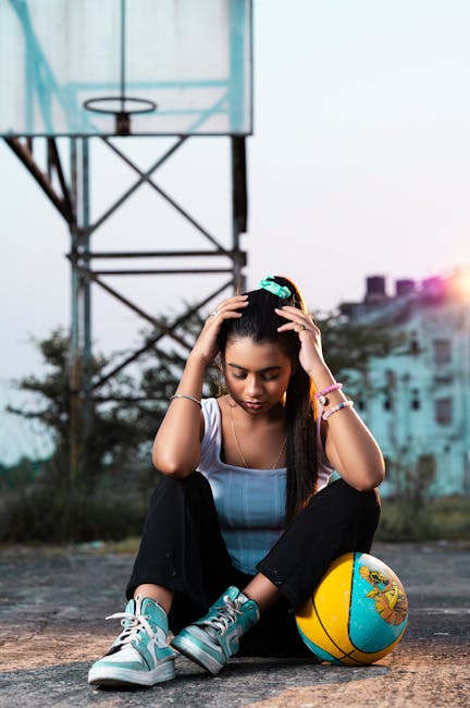 A woman in urban athletic wear with a basketball background