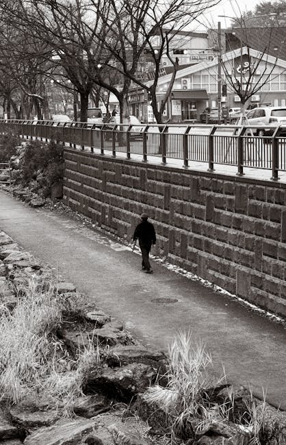 A person walking down an urban stone path in black and white