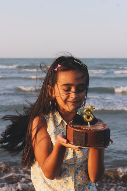 A young girl celebrating with a birthday cake by the ocean representing lifestyle milestones